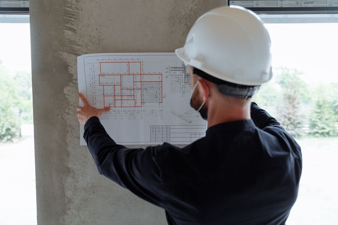 Engenheiro analisa planta de construção no canteiro de obras