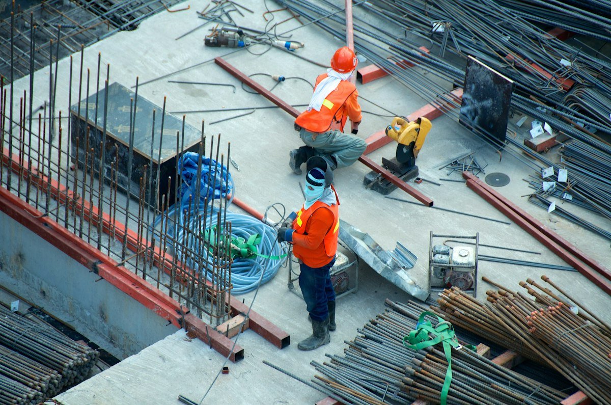 Trabalhador em canteiro de obras com estrutura de concreto em construção
